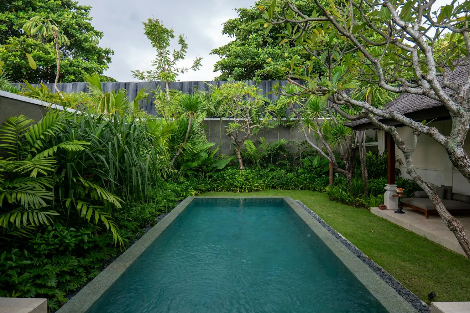 A Bali villa pool surrounded by lush tropical greenery