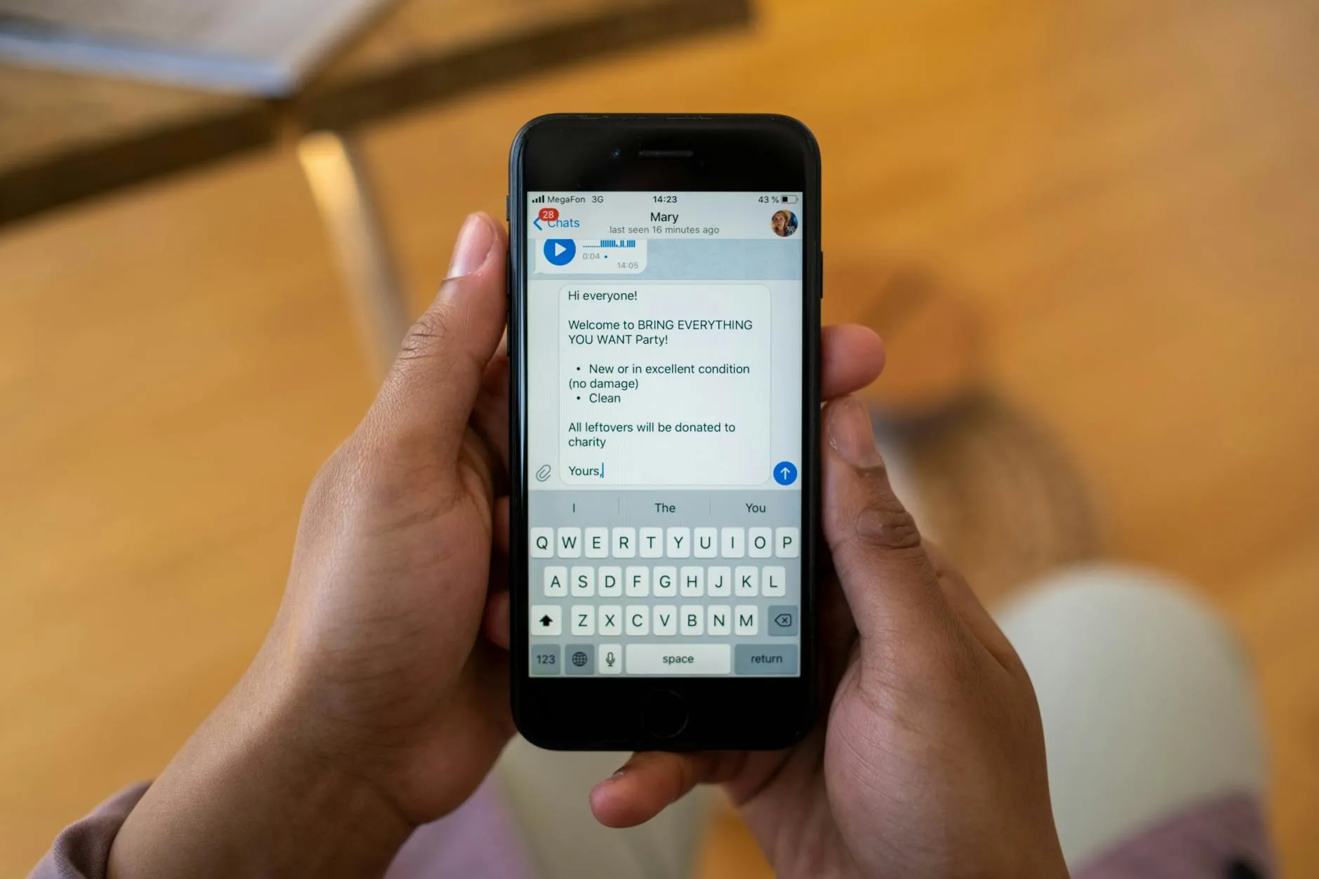 A villa host's phone showing a WhatsApp chat beside a poolside lounger at dusk