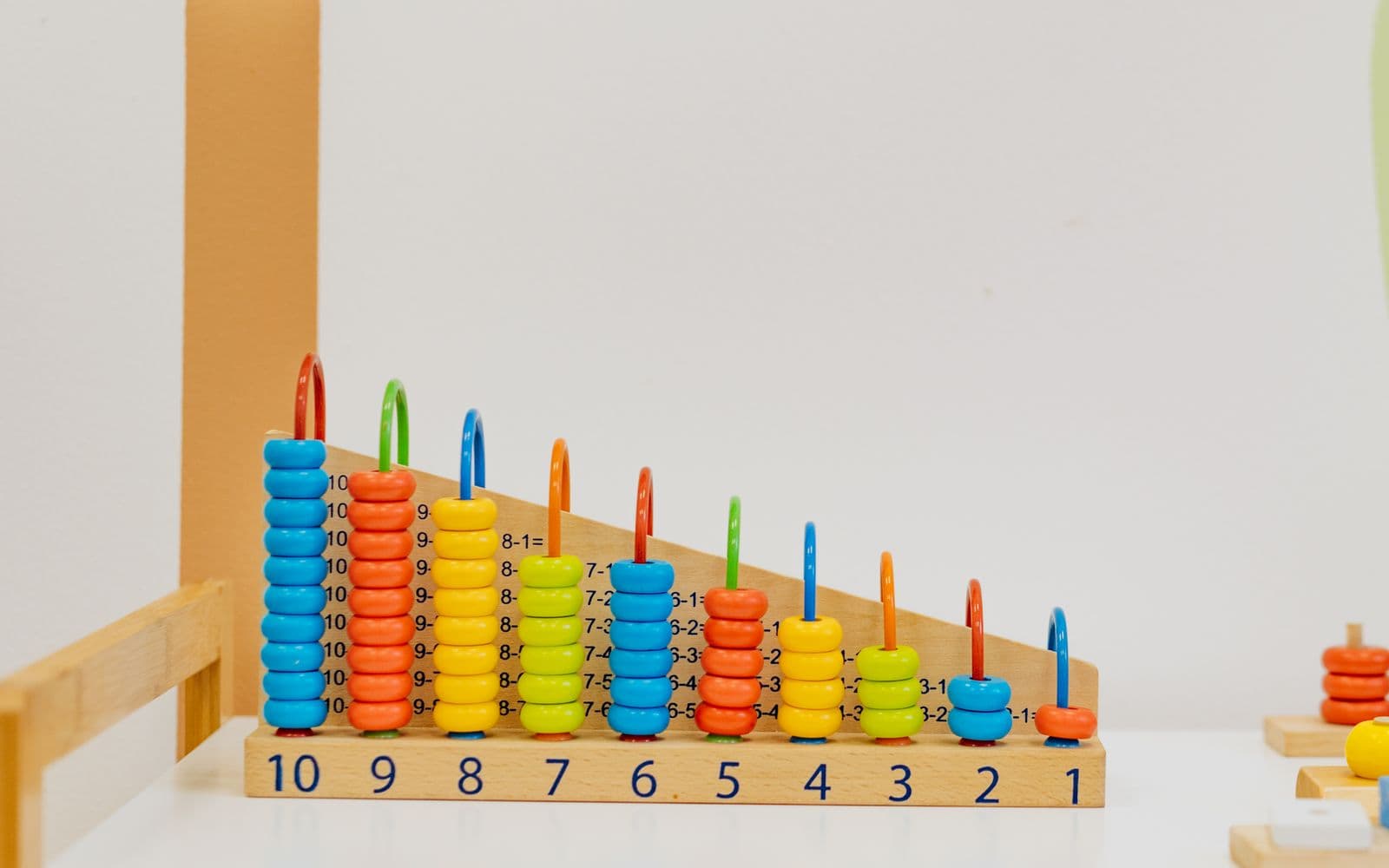 Close-up of a colorful wooden counting toy with numbers and shapes, perfect for preschool learning.