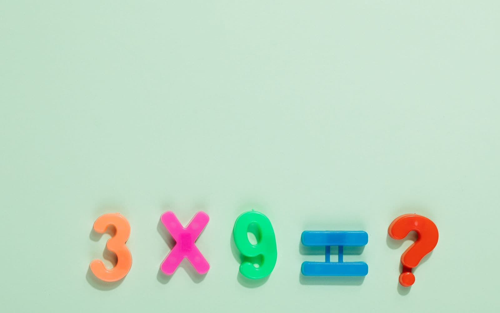 Colorful magnetic numbers and symbols on a pastel backdrop pose a math question.